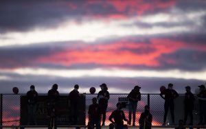 Fans stand atop the bleachers on a Friday evening at a recent home football game.